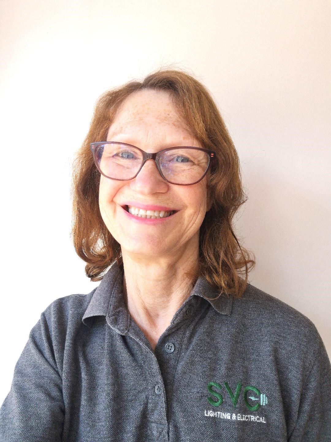 Image of a woman with auburn hair wearing a grey polo shirt