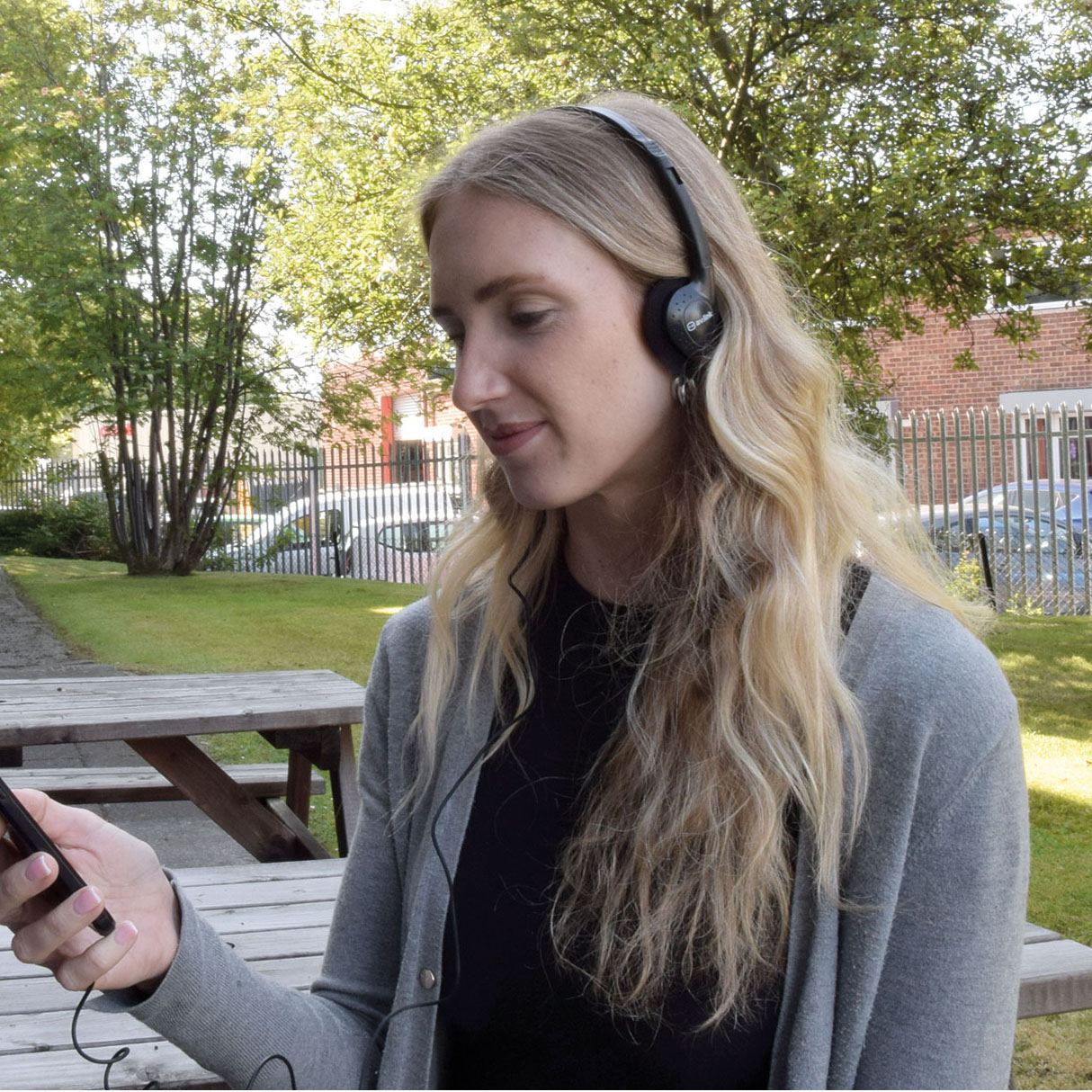 A Woman Wearing Black Lightweight Stereo Headphones Over Her Ears